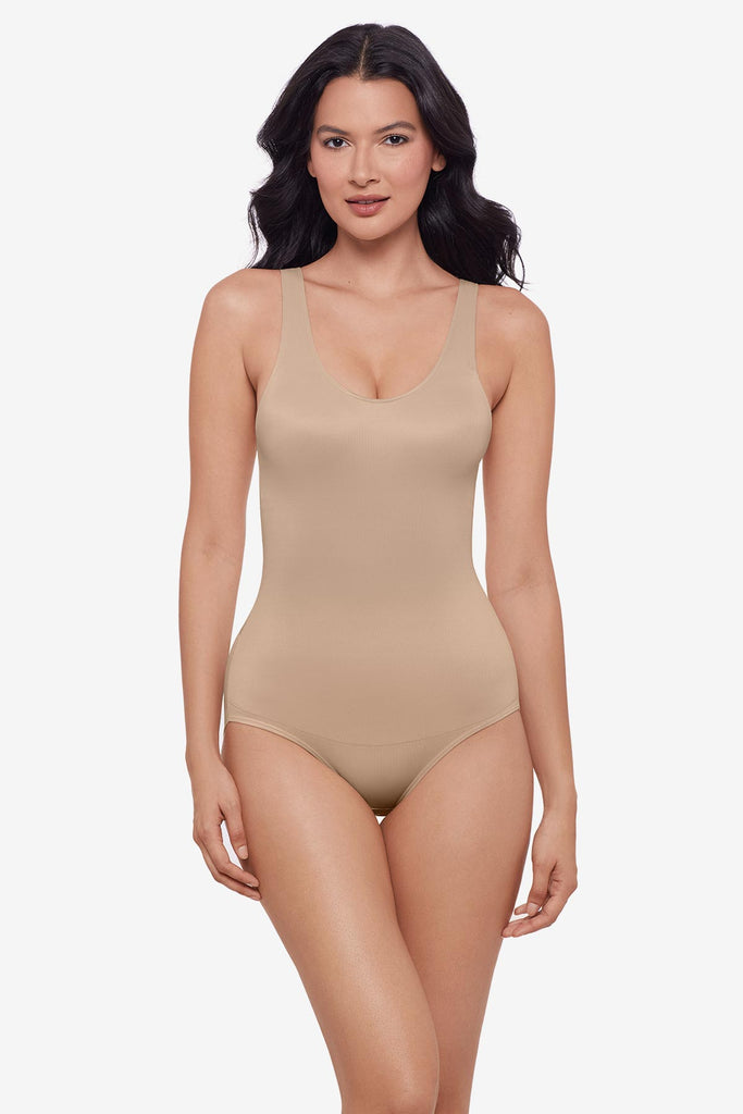 Woman wearing one-piece tan colored shapewear