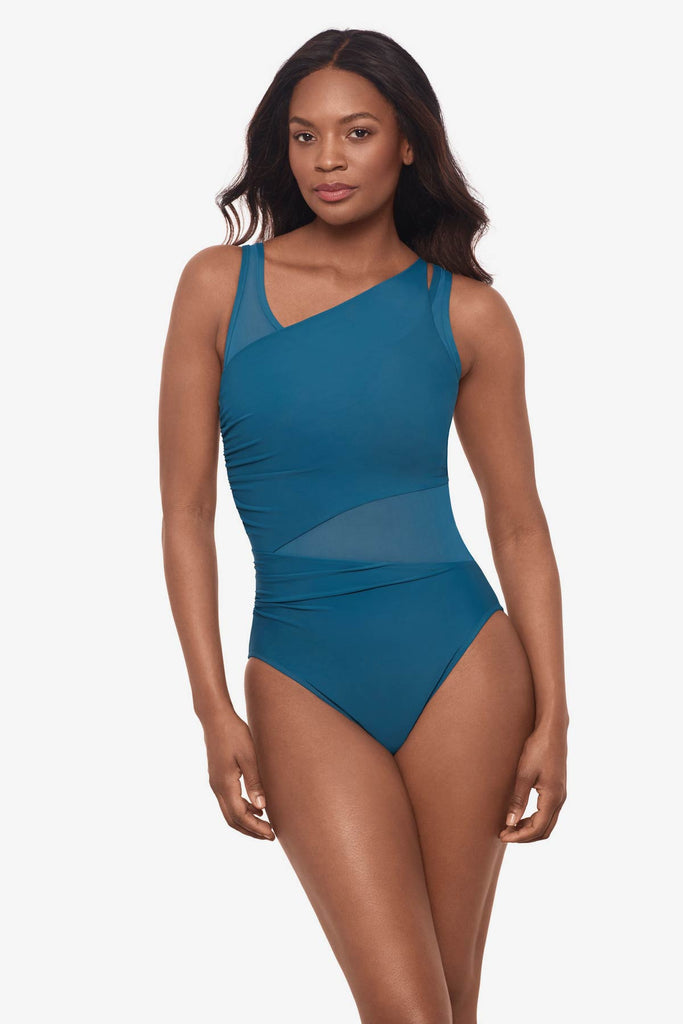 Woman wearing an aegean blue one-piece swimsuit with mesh cut outs throughout suit