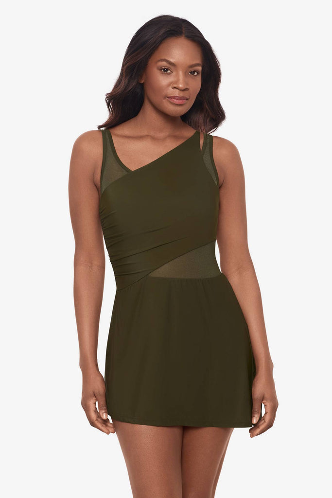 Woman wearing a nori green swim dress with a mesh cut out on the right