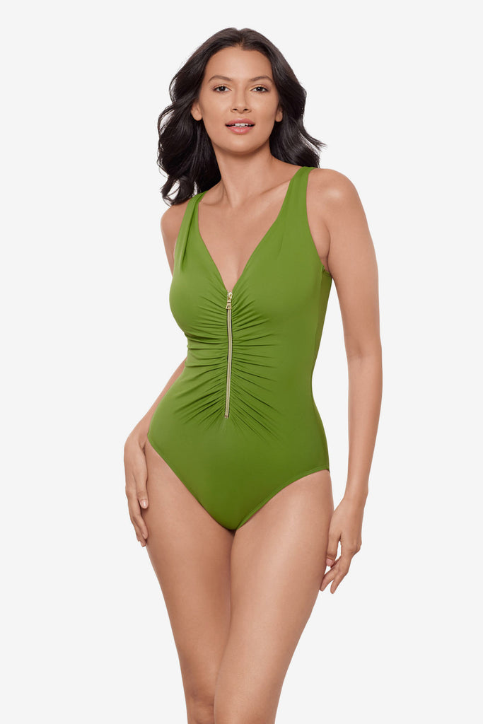 Woman wearing a bright green one-piece swimsuit with a zip down the front