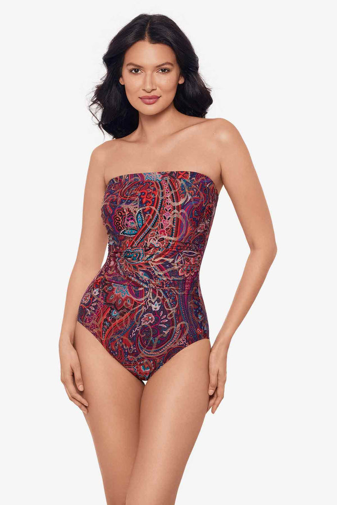 Woman wearing a bandeau one-piece swimsuit with an abstract print