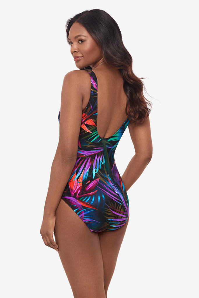 Woman facing left to show off the side detail on the multicolor one-piece swimsuit