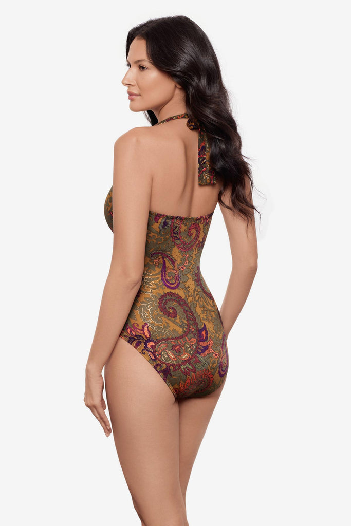 Woman turned left wearing a halter one-piece swimsuit with brown paisley print