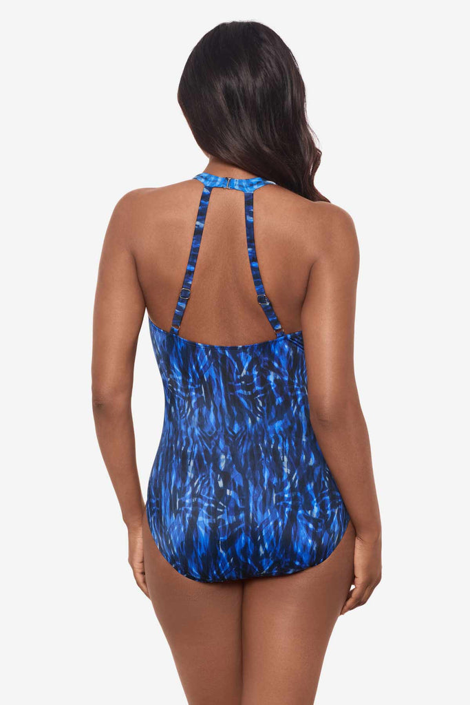 Woman facing away wearing a blue one-piece swimsuit 