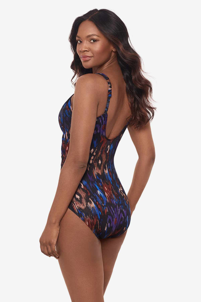 Woman turned left showing off side of one-piece multicolored swimsuit