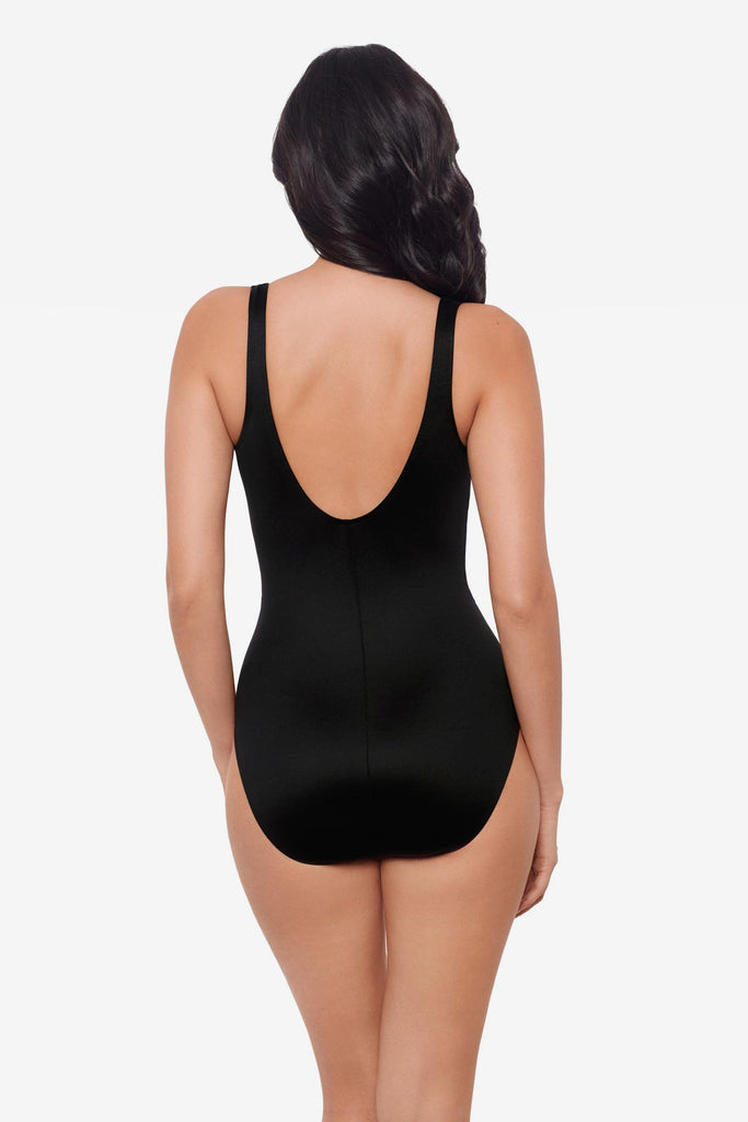 Woman facing away wearing a black one-piece swimsuit