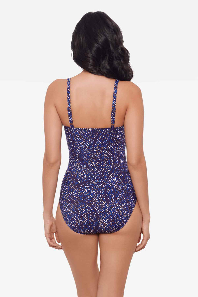 Woman facing away to show off the back of the one-piece multicolored swimsuit