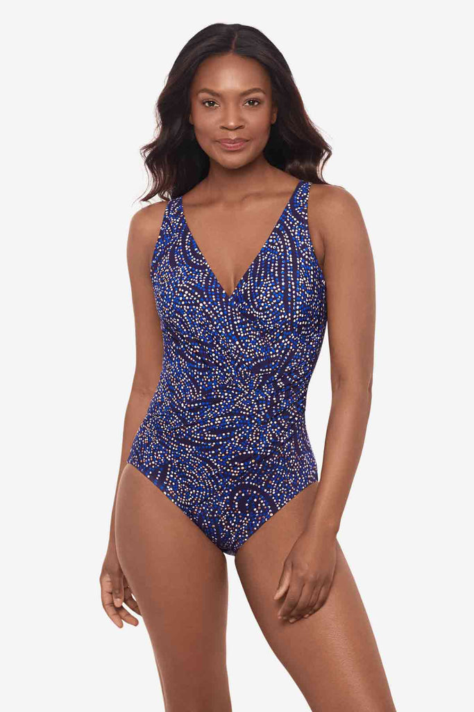 Woman wearing a one-piece multicolor swimsuit with abstract dots