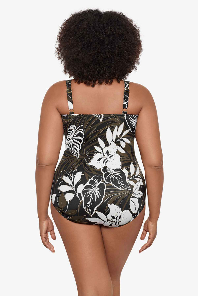 Woman facing away wearing a multicolor one-piece swimsuit with large white flowers