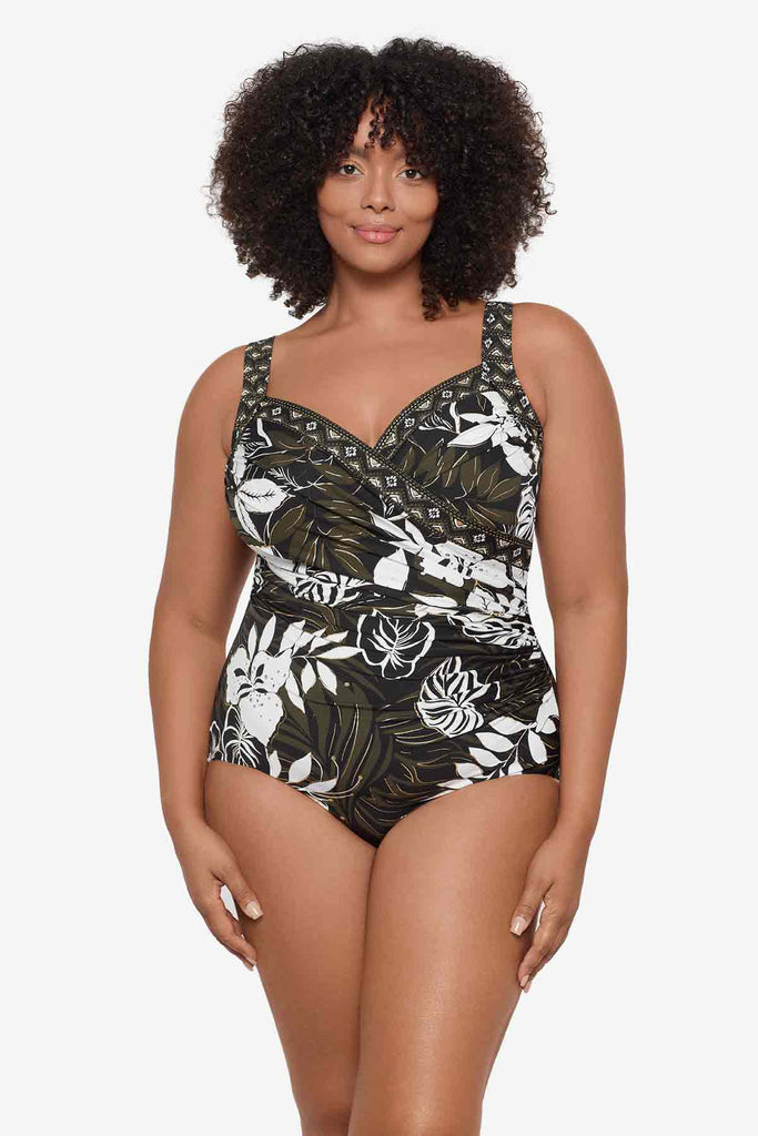 Woman wearing a multicolor one-piece swimsuit with large white flowers