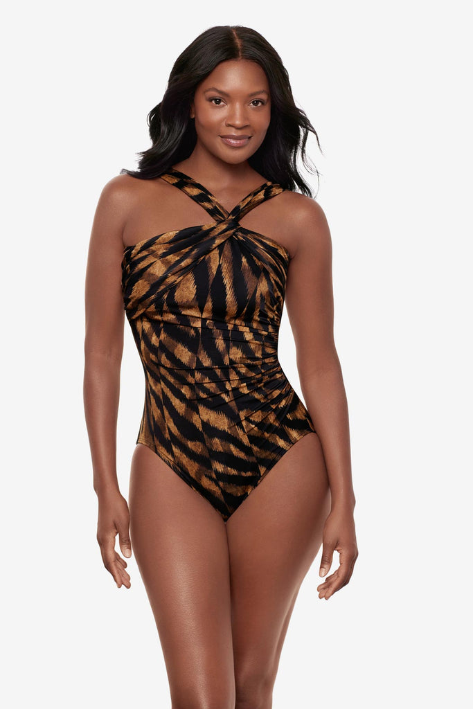 Woman wearing a black and brown printed one-piece swimsuit with a halter tie