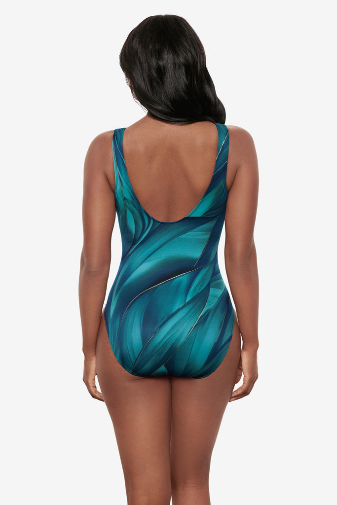 Woman turned away wearing a multi-blue one-piece swimsuit with gold details