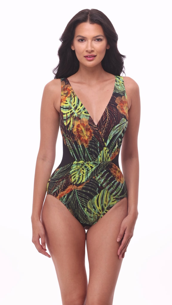 Woman wearing a multicolored palm leaf print one-piece swimsuit with a V neckline