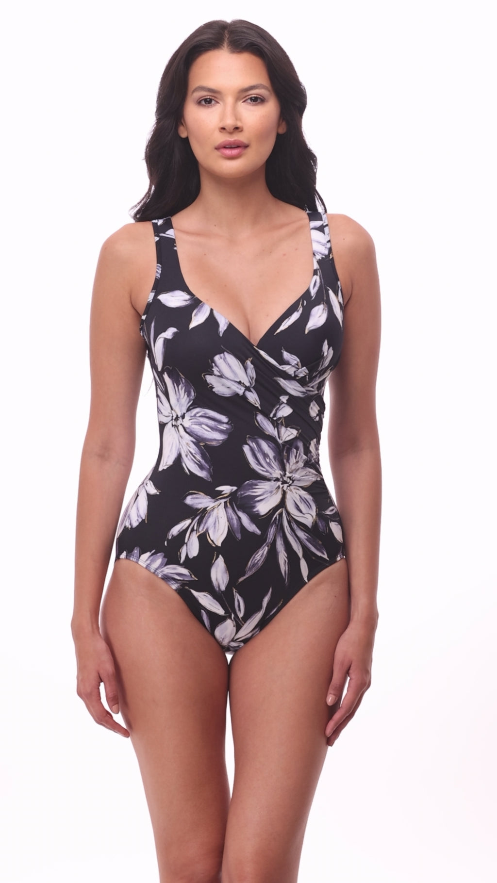 Woman wearing a black and white floral printed one-piece swimsuit with a sweetheart neckline